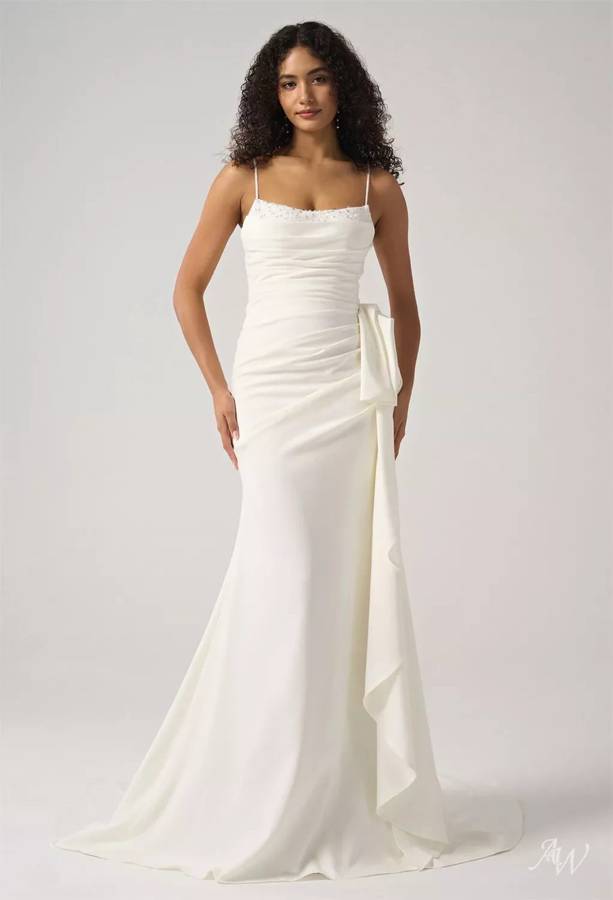 A fitted ivory gown with a beaded scoop neckline, ruched waist and a draped side bow