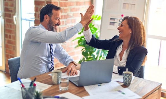 Couple celebrating agreement while finalizing their wedding guest list decisions